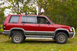 Right side view of a red Holden Jackaroo wagon fitted with a 40mm Ironman 4x4 Performance lift kit