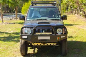 Full front on view of a brown Suzuki Jimny Sierra Wagon fitted with a massive 60mm Tough Dog 4x4 lift kit