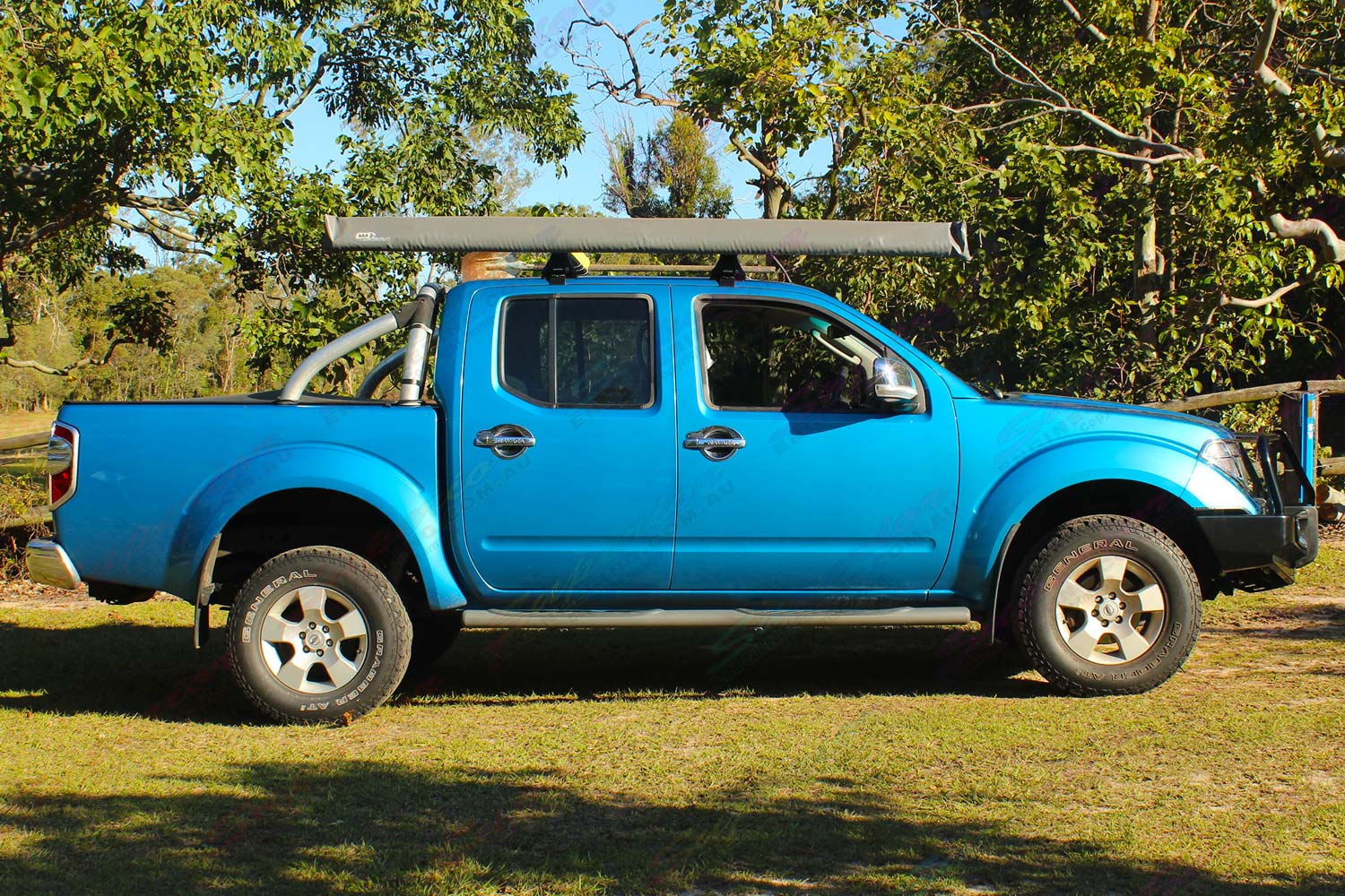 Right side view of a blue D40 Nissan Navara dual cab fitted with a 40mm Tough Dog lift kit, Ironman 4x4 bullbar & underbody protection