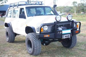 Front right view of a white GQ Nissan Patrol wagon after being fitted with a Superior and Profender Remote Reservoir Superflex 5 Inch Lift Kit
