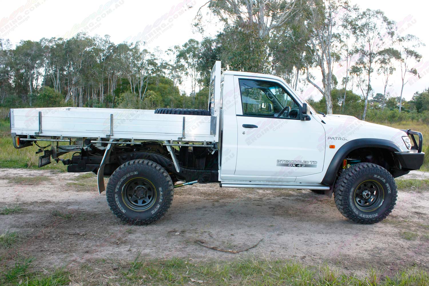 Right side view of a white GU Nissan Patrol single cab ute after being fitted with a 4 inch Superior Drop Box lift kit
