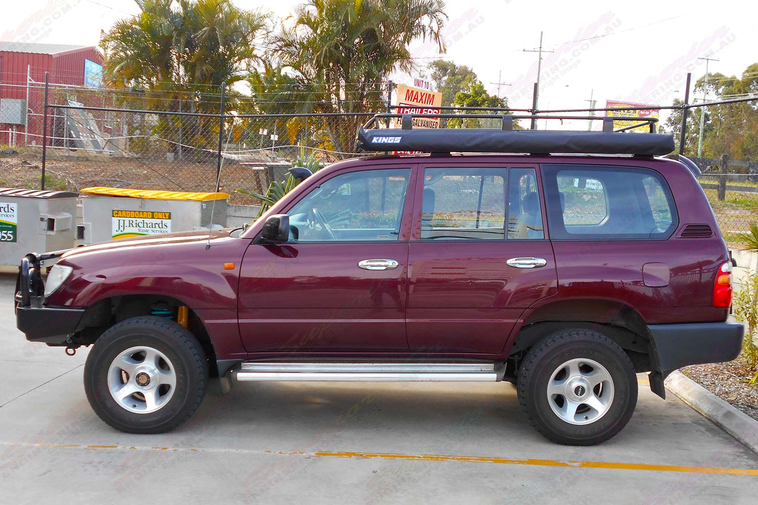 Left side view of a maroon 100 Series Toyota Landcruiser after being fitted with a heavy duty 2 inch Dobinsons 4x4 lift kit