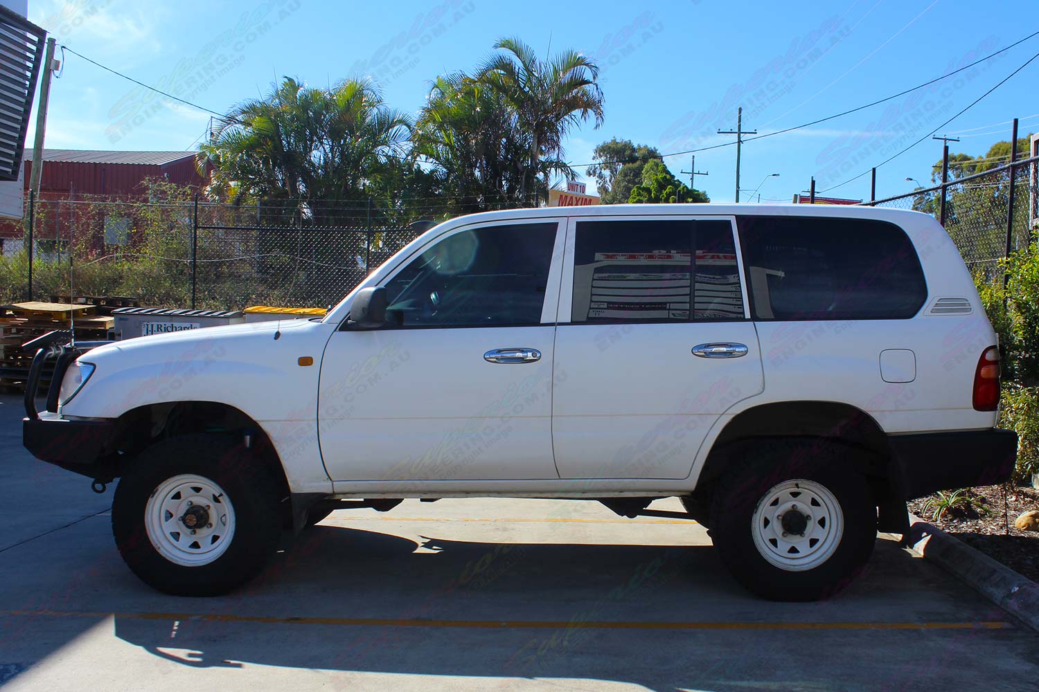 Left side view of a white 100 Series Toyota Landcruiser after being fitted with a heavy duty 2 inch Superior nitro gas lift kit
