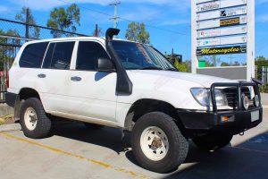 Right side view of a white 100 Series Toyota Landcruiser after being fitted with a heavy duty 2 inch Superior nitro gas lift kit
