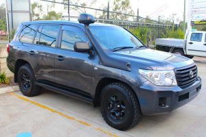 Right side view of a dark grey 200 Series Toyota Landcruiser (with KDSS) fitted with a set of heavy duty Superior Engineering stealth rock sliders