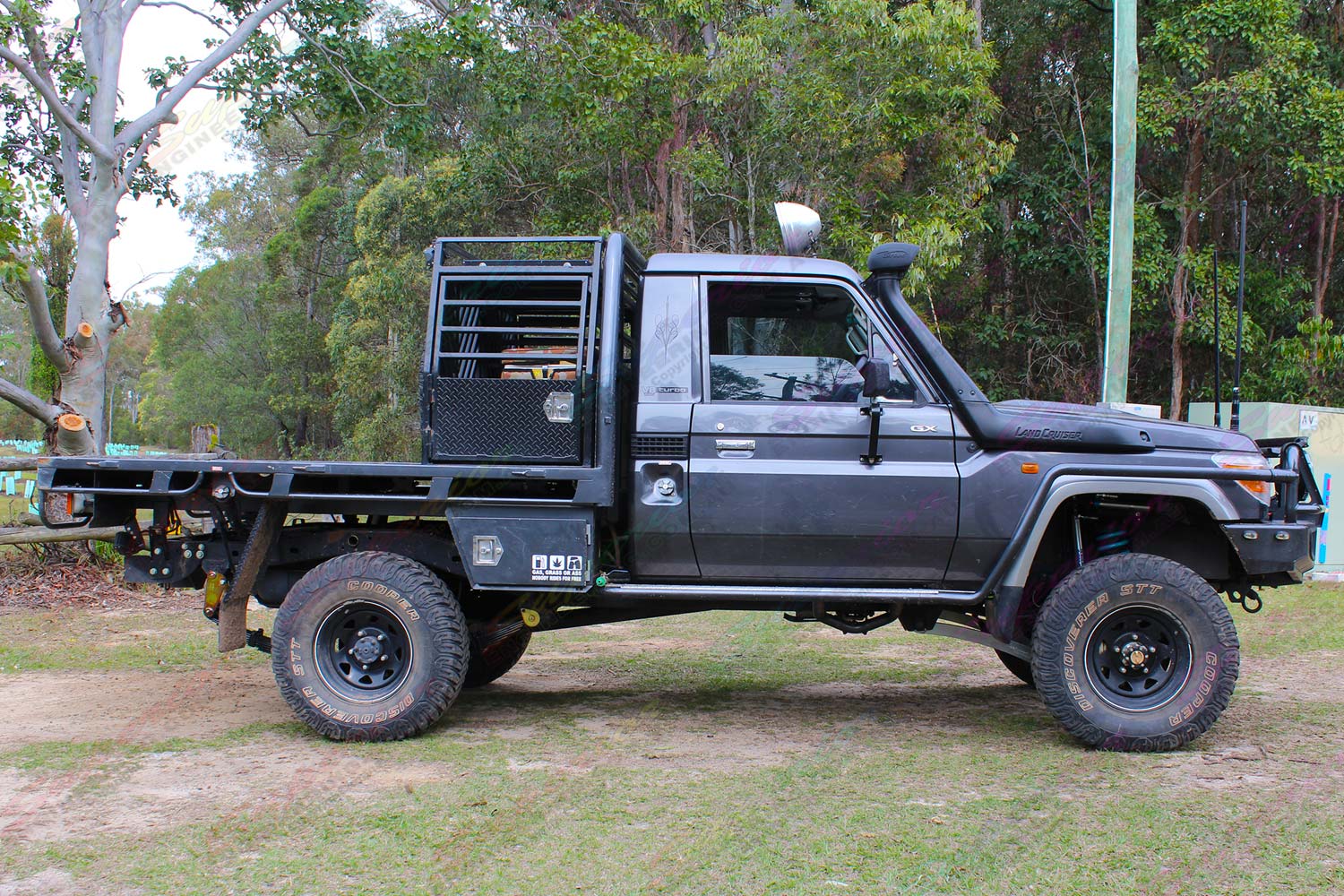 Right side view of a dark grey 79 series Toyota Landcruiser (single cab) ute after being fitted with a Superior Remote Reservoir Superflex 5 Inch Lift Kit