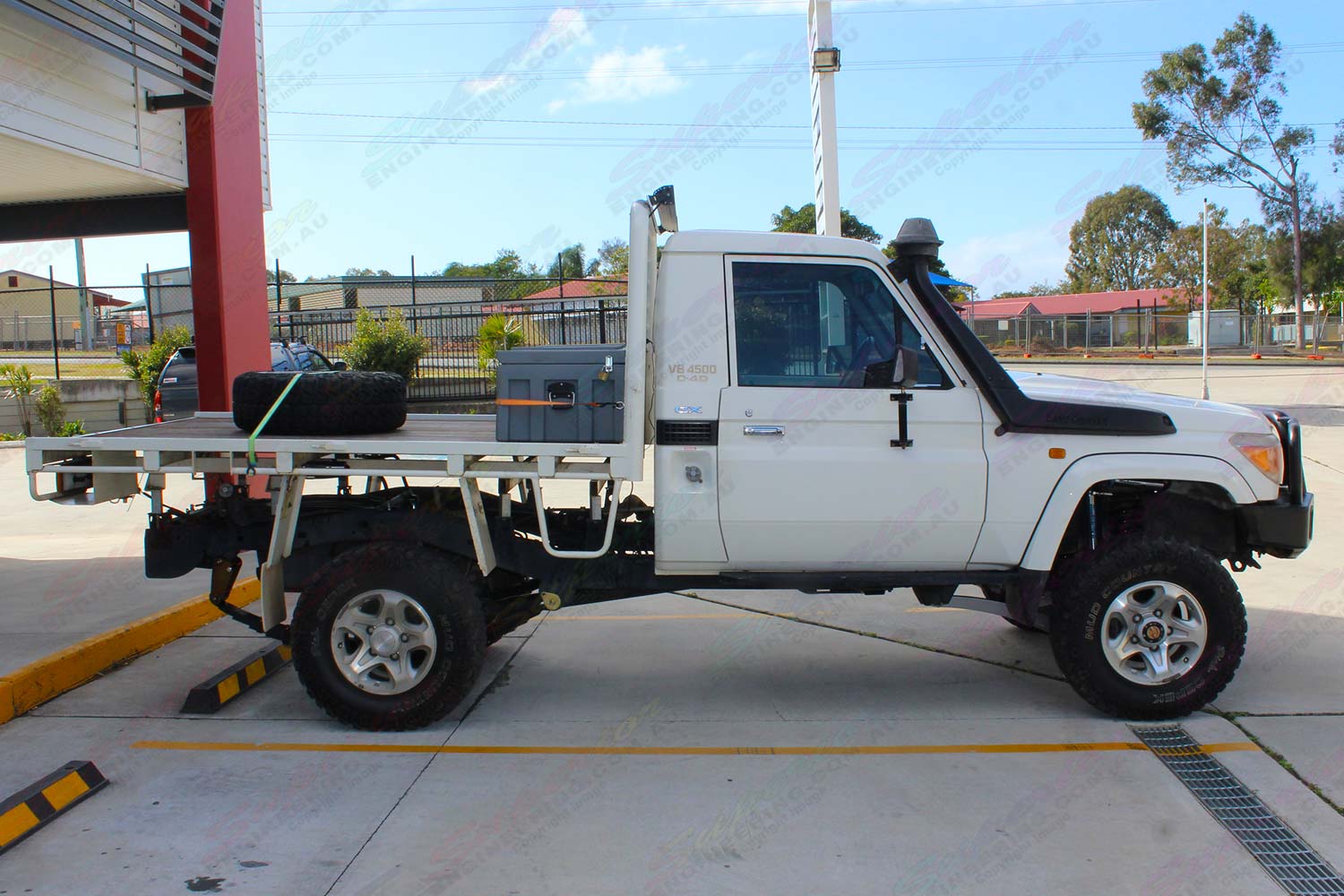 Right side view of a white 79 series Toyota Landcruiser (single cab) ute after being fitted with a Superior Remote Reservoir Superflex 4 Inch Lift Kit