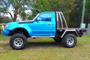 Left side view of a blue single cab 80 Series Toyota Landcruiser after being fitted with a premium Superior Remote Reservoir 5 Inch Lift Kit