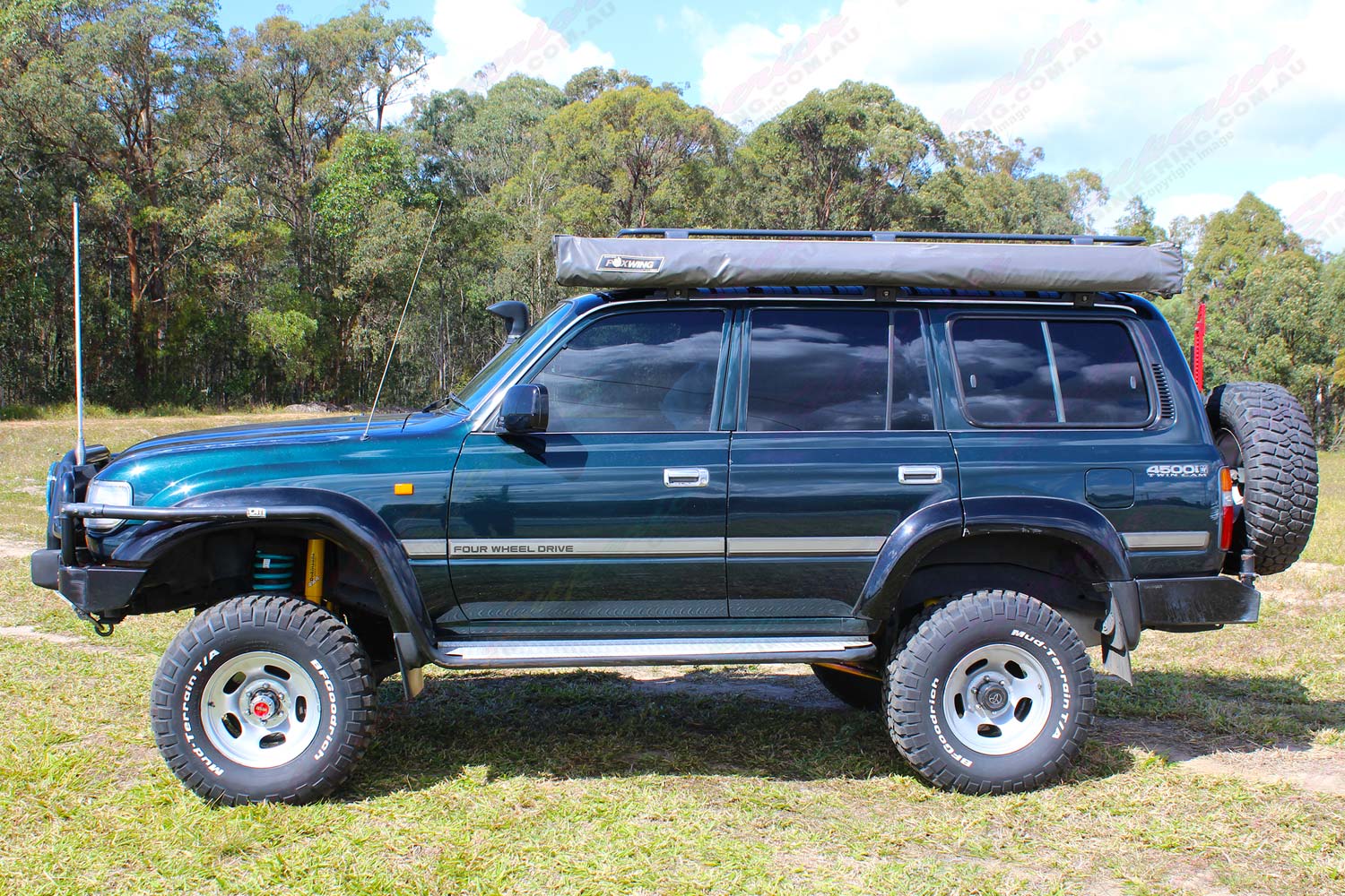 Left side view of a green 80 Series Toyota Landcruiser wagon fitted with dobinsons 4x4 4 inch coil springs and 6 inch shocks