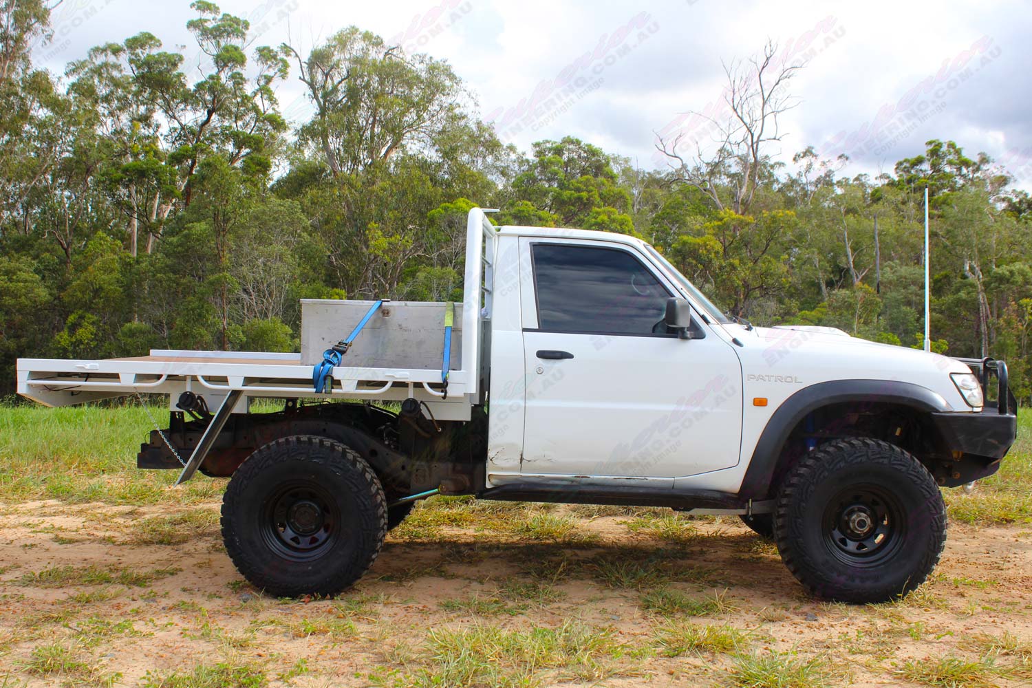 Right side view of a white Nissan Patrol GU Ute fitted with the heavy duty 4 inch Nitro Gas suspension kit