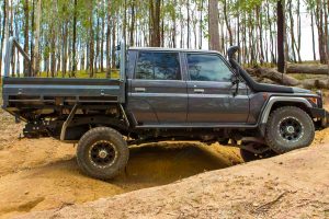 Right side of a dark grey 79 Series Toyota Landcruiser at Landcruiser Mountain Park testing out the new Superior rear coil conversion kit