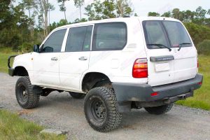 Rear left end view of a white 105 Series Toyota Landcruiser Wagon after being fitted with a 3 inch Superflex Tough Dog 4x4 lift kit