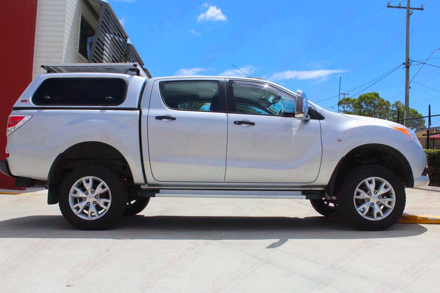 Right side view of a silver dual cab Mazda BT-50 after being fitted with a 2 inch lift kit at the Superior Engineering Deception Bay workshop