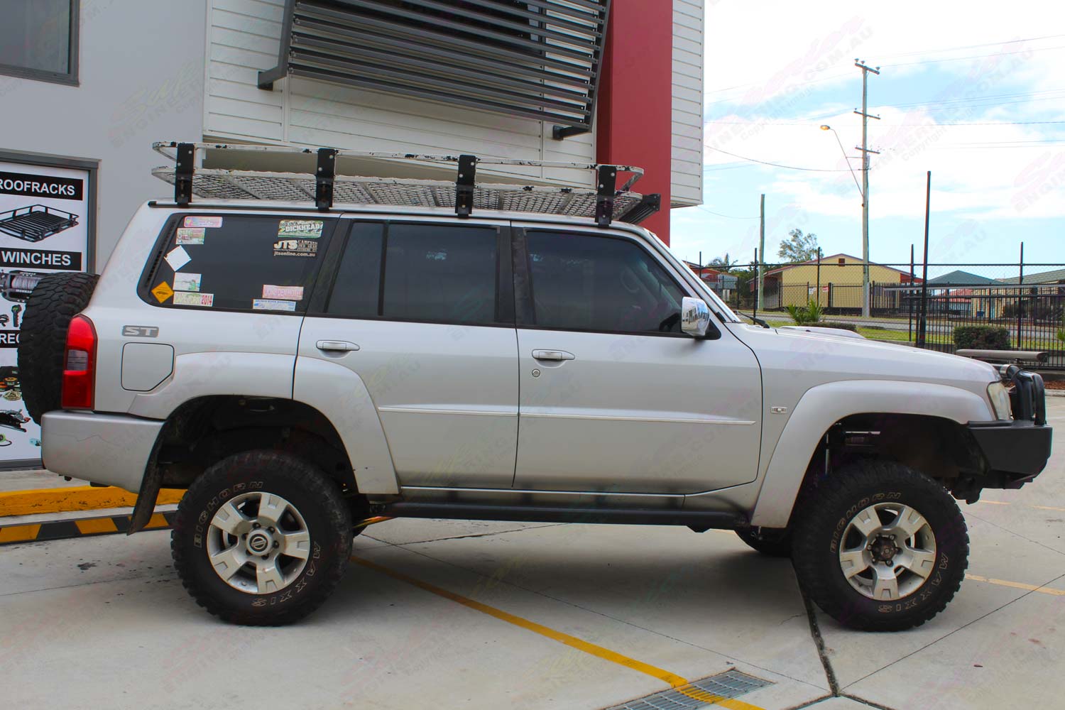 Right side view of a silver GU Nissan Patrol Wagon at the Deception Bay 4x4 showroom after fitting a 4 inch Superior Remote Reservoir Drop Box Lift Kit