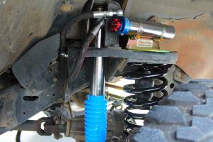 Closeup under vehicle view of a superior remote res shock, coil spring, reservoir mount and bumpstop extension fitted to the GU Nissan Patrol Wagon