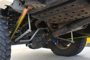 Closeup under vehicle view of the lower and upper rear control arms, superflex swaybar, extensions and black coils fitted to a GU Nissan Patrol wagon
