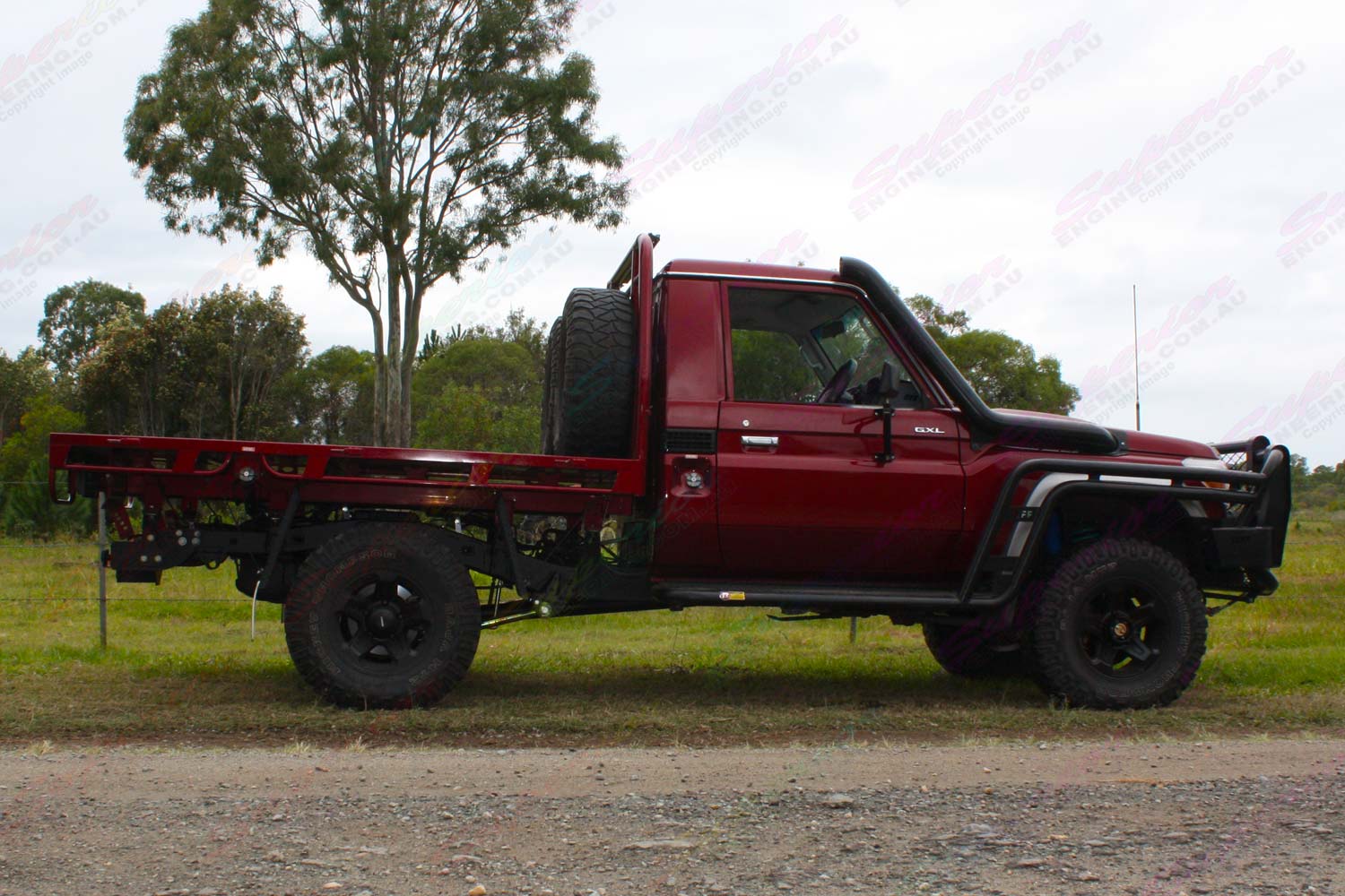 Right side view of a Maroon 79 Series Toyota Landcruiser (Single Cab) at Superior Engineering fitted out with a new rear coil conversion kit