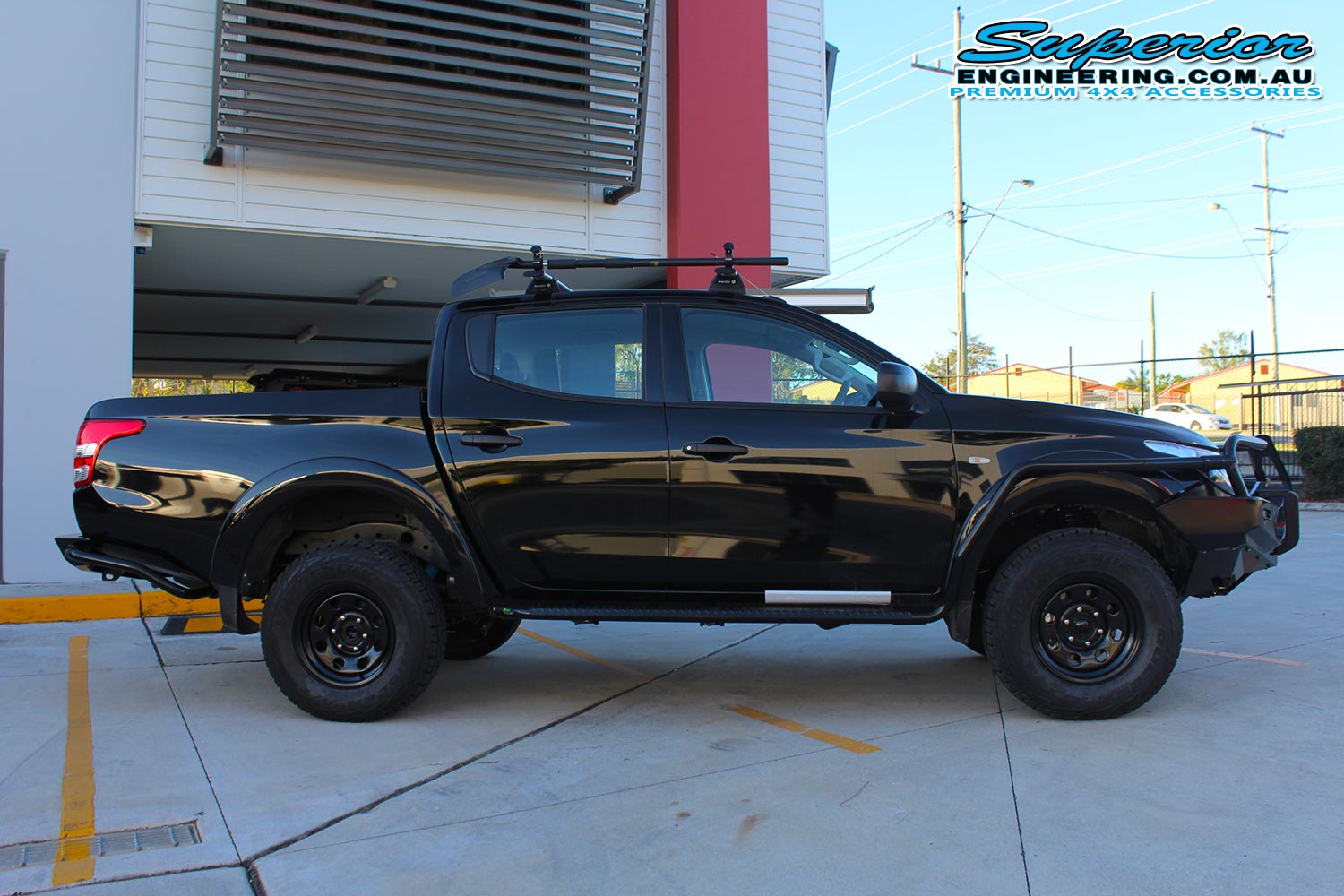 Right side view of a black Mitsubishi MQ Triton fitted with a 40mm Bilstein lift kit and Ironman 4x4 Accessories