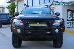 Full front view of a MQ Mitsubishi Triton dual cab fitted with an Ironman 4x4 black deluxe commercial bullbar and led light bar at the Deception Bay 4WD retail store