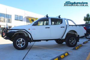 Left side view of a white Mitsubishi Triton four wheel drive after being fitted with a 20mm Bilstein lift kit and a full range of 4x4 accessories from Superior Engineering