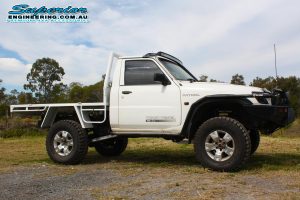 Right side view of a white GU Nissan Patrol ute after being fitted with a complete Superior Engineering 4x4 accessory and suspension fitout