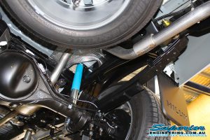Closeup view of a single Bilstein shock, leaf spring, u-bolts and shackle fitted to the rear of a new Toyota Hilux Revo four wheel drive