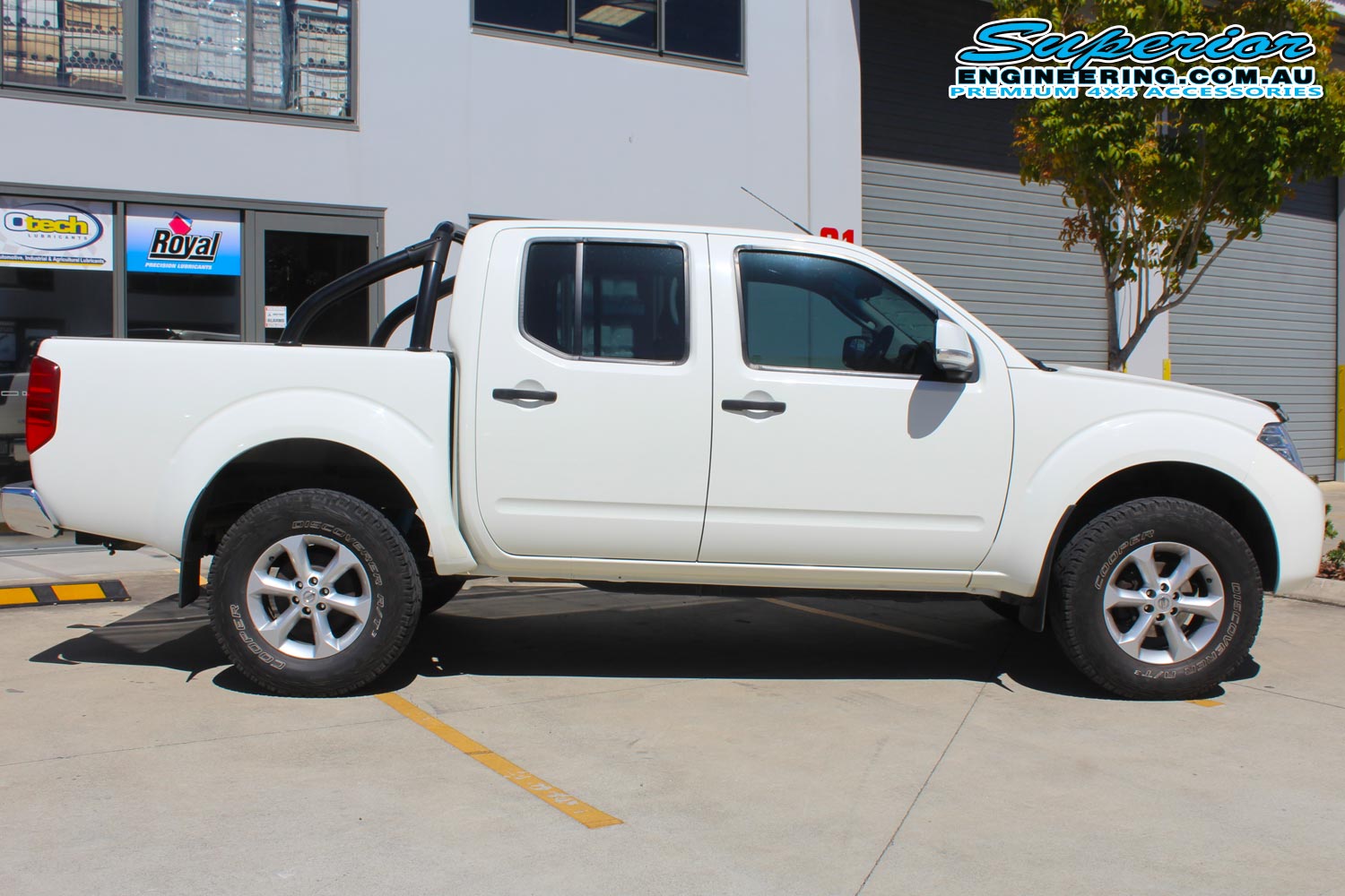 Right side view of a white Nissan Navara D40 dual cab after being fitted with a 2 inch Bilstein lift kit