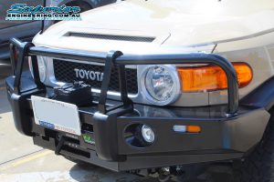 Front left view of the Toyota FJ Cruiser fitted with an Ironman 4x4 Black Commercial bullbar at the Deception Bay 4WD Retail Showroom