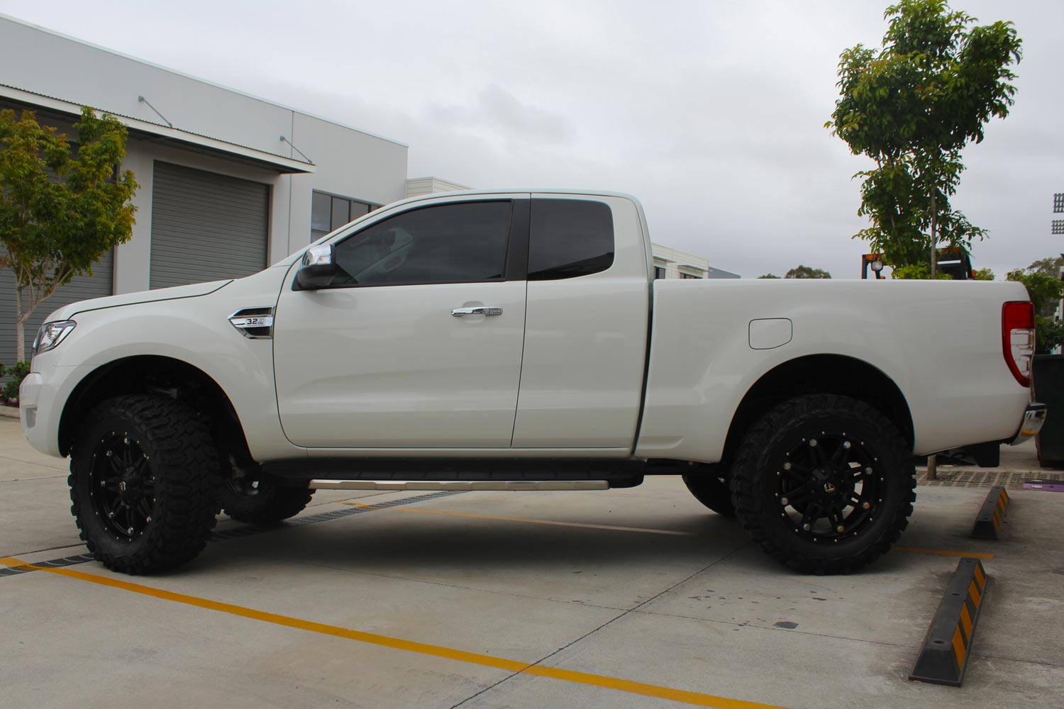 Left side view of a white Ford Ranger fitted with a heavy duty 3 inch Nitro Gas lift kit from Superior Engineering
