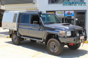 Front right view of a grey dual cab 79 Series Toyota Landcruiser after fitting the 2 inch Superior Remote Reservoir lift kit in the Superior DBay Showroom carpark