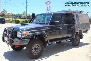 Front left view of a grey dual cab 79 Series Toyota Landcruiser after fitting the 2 inch Superior Remote Reservoir lift kit at the Superior Engineering Deception Bay Showroom car park