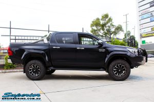 Side view of a Black Toyota Hilux Revo before fitting a 2" inch lift with Superior Remote Reservoir Rear Shock & Front Strut and Coil & Leaf Springs