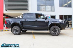 Side view of a Black Toyota Hilux Revo after fitting a 2" inch lift with Superior Remote Reservoir Rear Shock & Front Strut and Coil & Leaf Springs