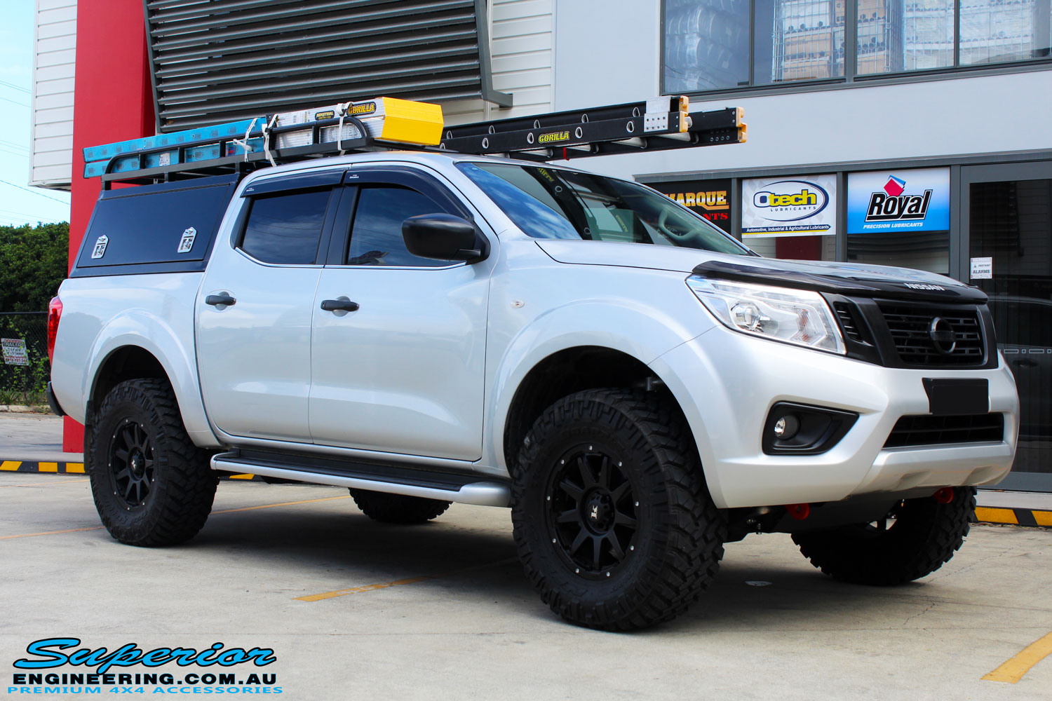 Right front side view of a Grey Nissan NP300 Navara Ute after fitment of a Superior Nitro Gas 2" Inch Lift Kit + Airbag Man 2" Coil Air Kit Helper, Ironman 4x4 Flomax Air Compressor and Nitto Trail Grappler Tyres with King Gator Wheels