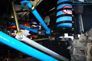 Left side view of under the tray after fitment showing Remote Reservoir Shock, Coil Spring with Airbag Man Coil Helper and Lower & Upper Control Arms.