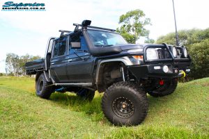 Front right side view whilst flexing of a Grey Toyota 79 Series Landcruiser Dual Cab after fitment of a Superior 4" Inch Rear Coil Conversion Kit with Hyperflex Radius Arms, Remote Reservoir Shocks and a Airbag Man 4" Inch Coil Helper Air Kit.