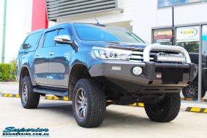 Right front side view of a Grey Toyota Hilux Revo Dual Cab after fitment of a Superior Remote Reservoir 4" Inch Lift Kit