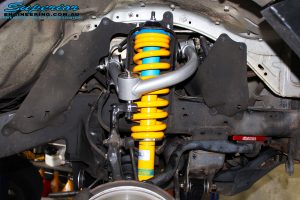 Front right inside guard view of the fitted Bilstein 4" Strut + Superior Coil Spring, Upper Control Arm & Sway Bar Relocation Plate