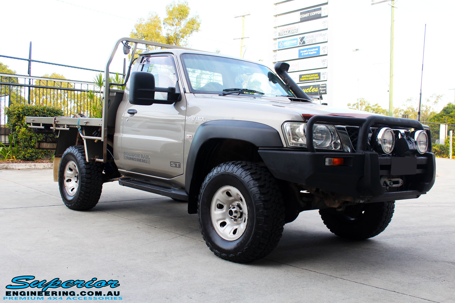 Right front side view of a Nissan GU Patrol Ute in Gold On The Hoist @ Superior Engineering Deception Bay Showroom