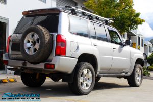Back right view of a Silver Nissan GU Patrol Wagon after fitting a Dobinson 2" Inch Lift Kit + Coil Tower Brace Kit