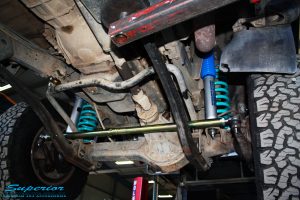 Mid underbody view looking front on of the fitted Superior Tie Rod Bar, Nitro Gas Shocks + Coil Springs
