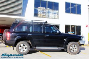 Right side view of a Black Nissan GU Patrol Wagon being fitted with a Superior 2" Inch Nitro Gas Lift Kit, Airbag Man 2" Inch Coil Air Helper Kit, Safari Snorkel, Brown Davis Long Range Fuel Tank, Superior Coil Tower Brace Kit & Superior Upper Control Arms