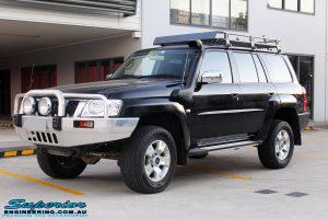 Left front side view of a Black Nissan GU Patrol Wagon after being fitted with a Superior 2" Inch Nitro Gas Lift Kit, Airbag Man 2" Inch Coil Air Helper Kit, Safari Snorkel, Brown Davis Long Range Fuel Tank, Superior Coil Tower Brace Kit & Superior Upper Control Arms