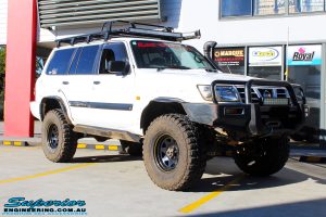 Right front side view of a White Nissan GU Patrol Wagon being fitted with Superior Hybrid 5 Link Radius Arms, 55mm Shock Tower Lift Kit & Bump Stop Extensions