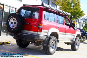 Rear right side view of a Red Toyota 80 Series Landcruiser after fitment of a Fox 2.0 Performance Series IFP 2" Inch Lift Kit