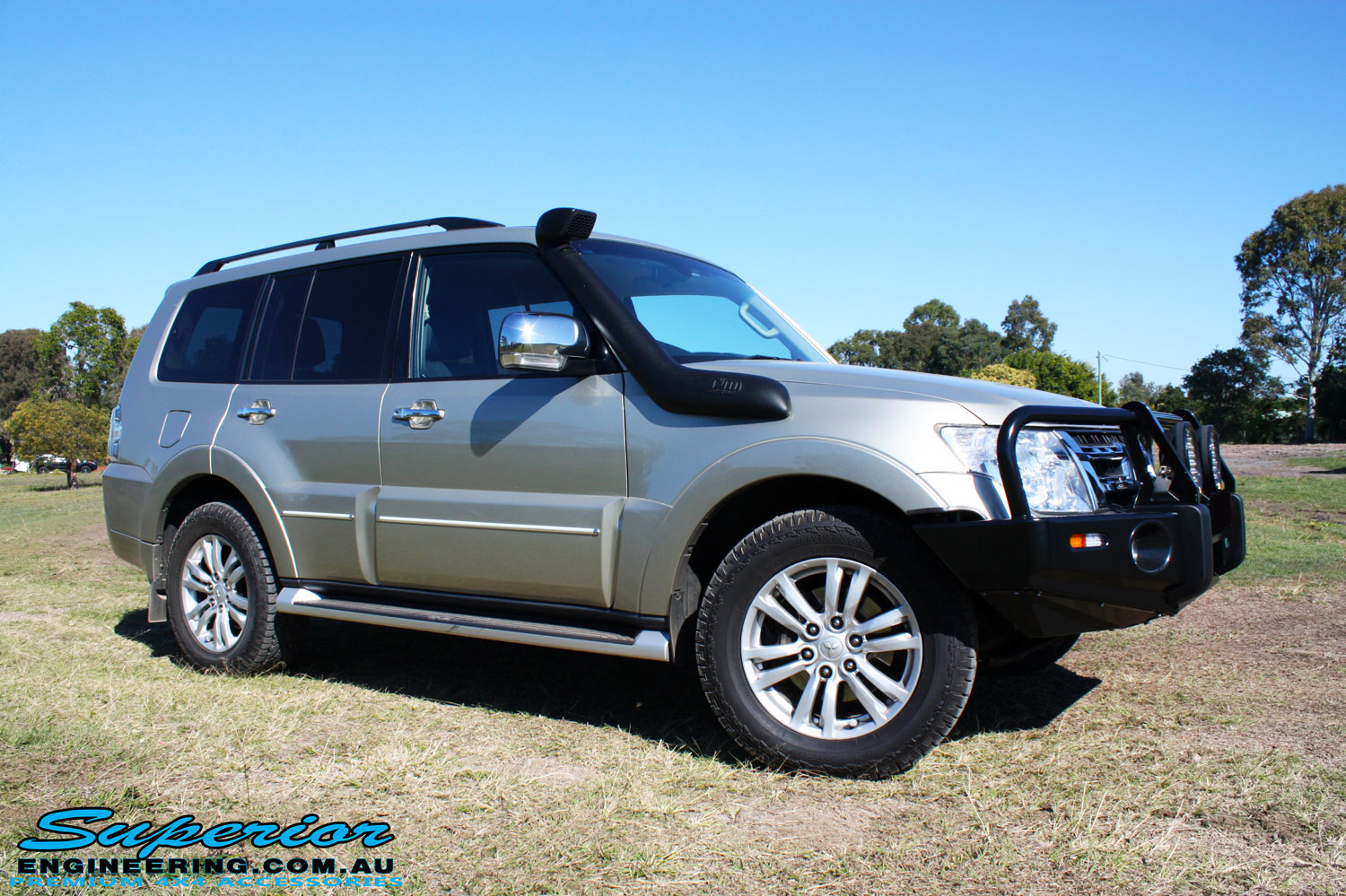 Right front side view of a Mitsubishi Exceed Pajero Wagon in Gold after fitment of a Ironman 4x4 Deluxe Black Commercial Bull Bar