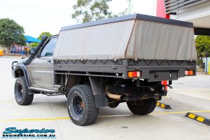 Rear left view of a Gold Nissan GU Patrol Ute being fitted with Superior Superflex Sway Bar Kit & a Superior Shock Tower Kit