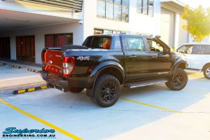 Rear right outside view of a Ford PXII Ranger in Black flexing up after fitment of a Superior 3" Inch Remote Reservoir Lift Kit, Rhino 4x4 Winch Bar, VRS Winch, GME UHF CB & Antenna, Nitto Ridge Grappler Tyres & Fuel Vaper Matte Black Wheels