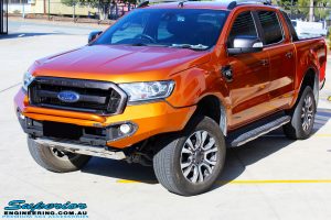Left front side view of a Orange Ford PXII Ranger Dual Cab after fitment with a Rhino 4x4 Evolution 3D Winch Bar & Legendex 409 Stainless Steel 3" Inch Exhaust + Power Command Module