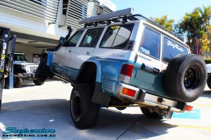 Left rear side view of a Blue Nissan GQ Patrol flexing its front left wheel after fitment of a Superior Remote Reservoir Hybrid Superflex 3" Inch Lift Kit